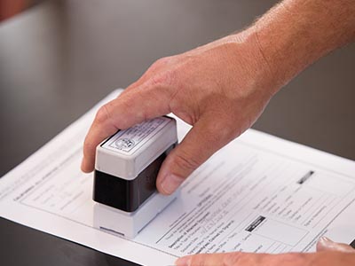Notary applying stamp to a document